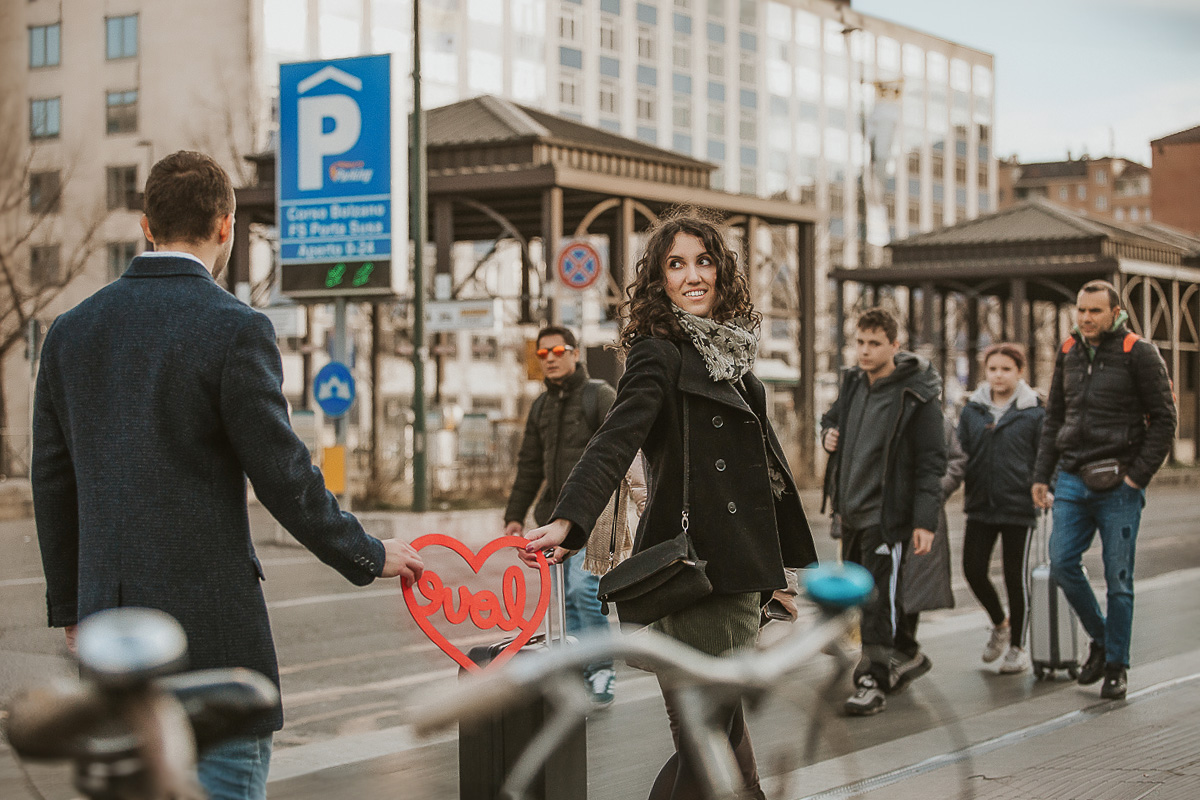 Engagement a Torino nella stazione di Porta Susa. La coppia si tiene in mano un cuore rosso con la scritta love