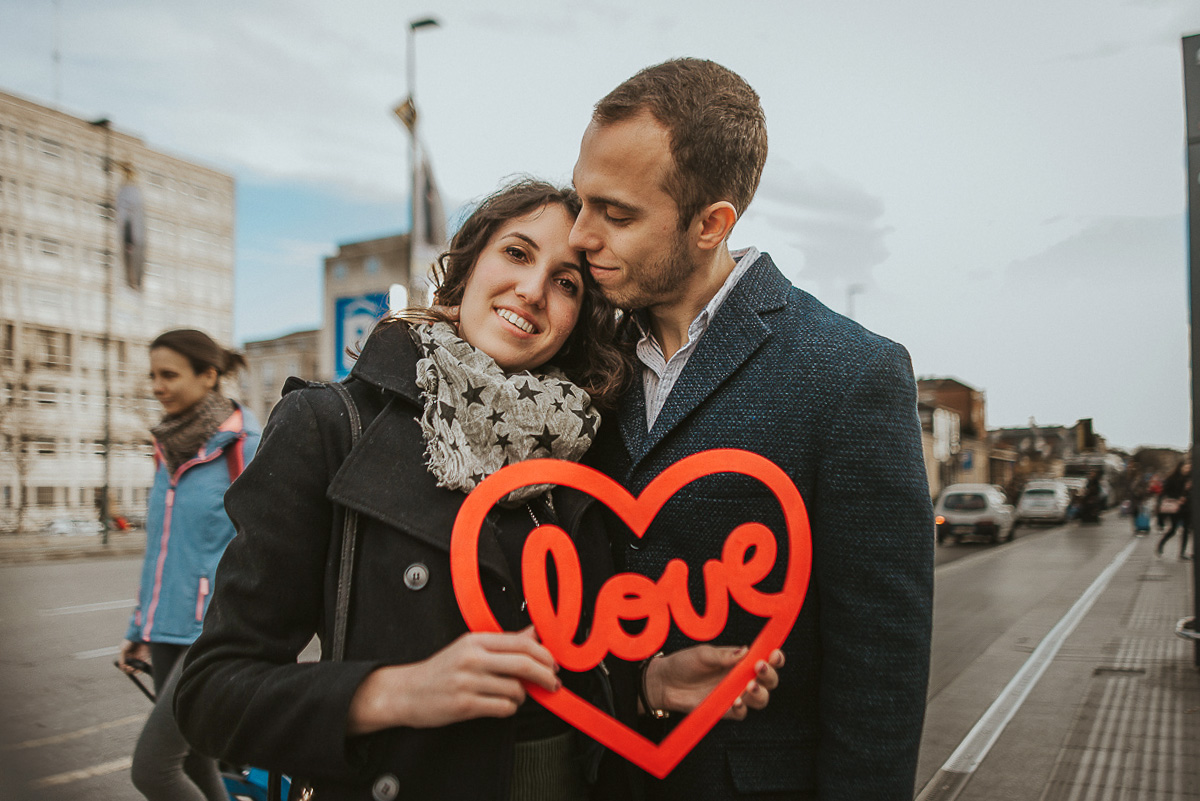 Engagement a Torino nella stazione di Porta Susa. La coppia si tiene in mano un cuore rosso con la scritta love