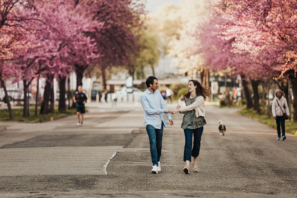 Servizio fotografico di coppia alla Crocetta di Torino. Coppia si cammina tra i ciliegi rosa in fiore.