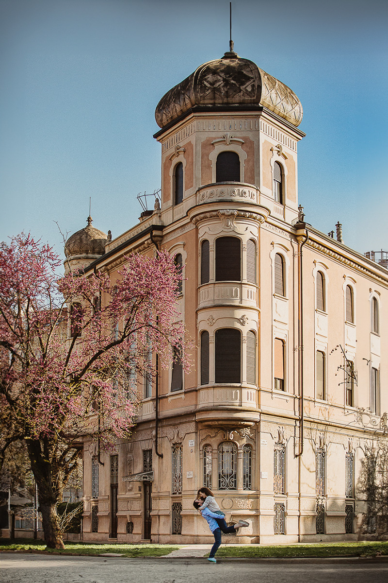 Servizio fotografico di coppia alla Crocetta di Torino. Marco solleva Cecilia davanti ad un bellissimo palazzo in stile eclettico, moresco.