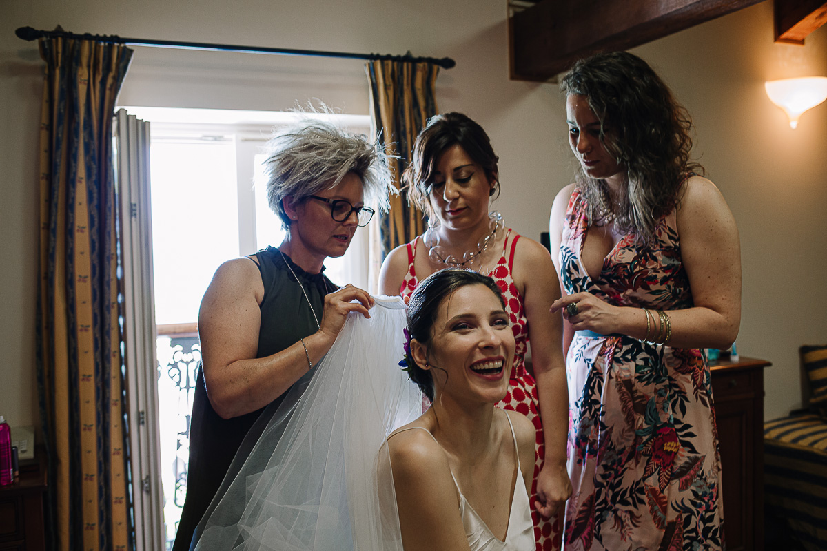 Castello Rosso di Costigliole di Saluzzo. Destination wedding. Parrucchiera spiega alle testimoni come togliere e mettere il velo alla sposa.