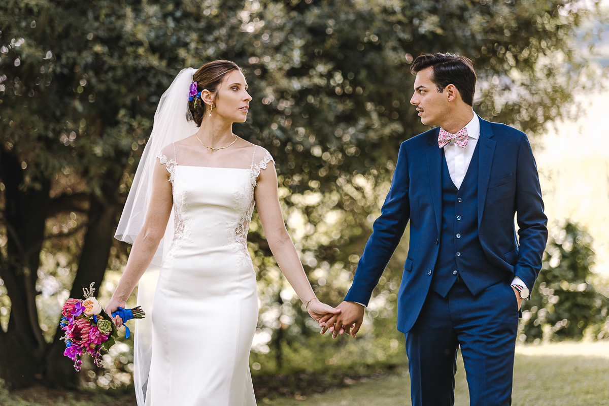 Castello Rosso di Costigliole di Saluzzo. Destination wedding. Sessione di coppia. Sposi camminano dandosi la mano.