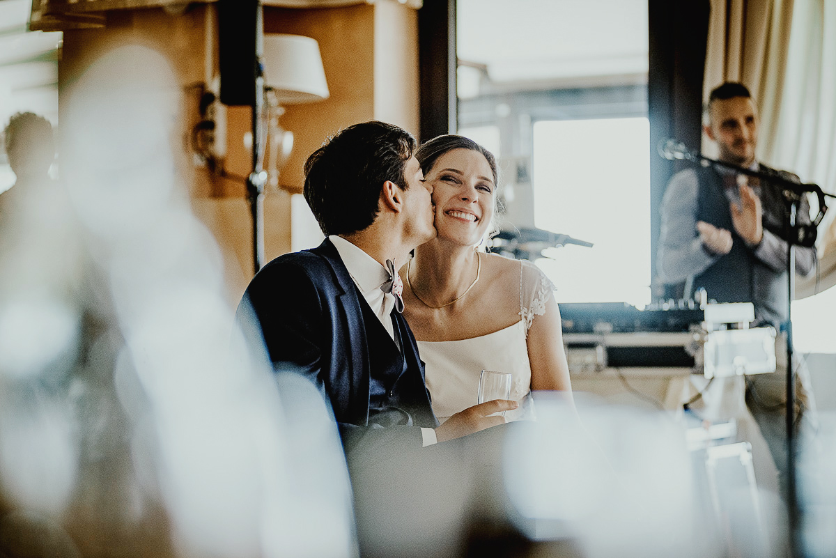Castello Rosso di Costigliole di Saluzzo. Destination wedding. Visione delle diapositive. Sposo bacia la sposa sulla guancia