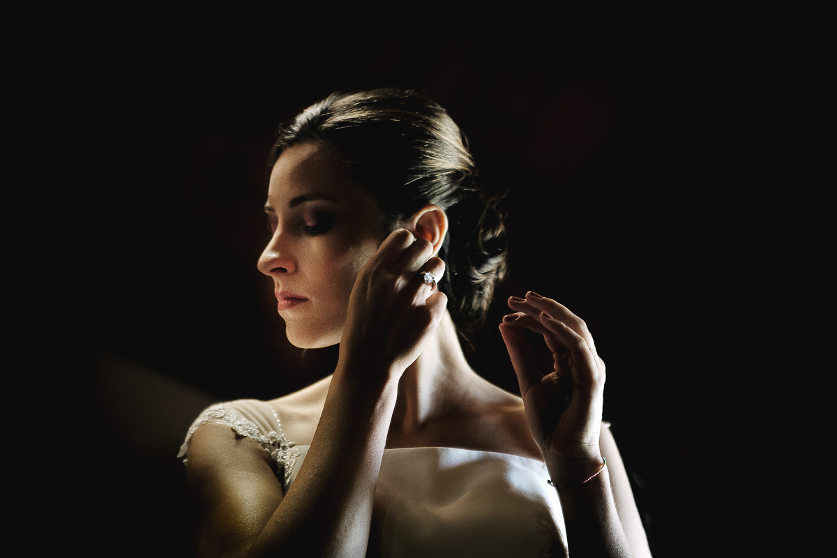 Castello Rosso di Costigliole di Saluzzo. Destination wedding. Sposa si mette gli orecchini.