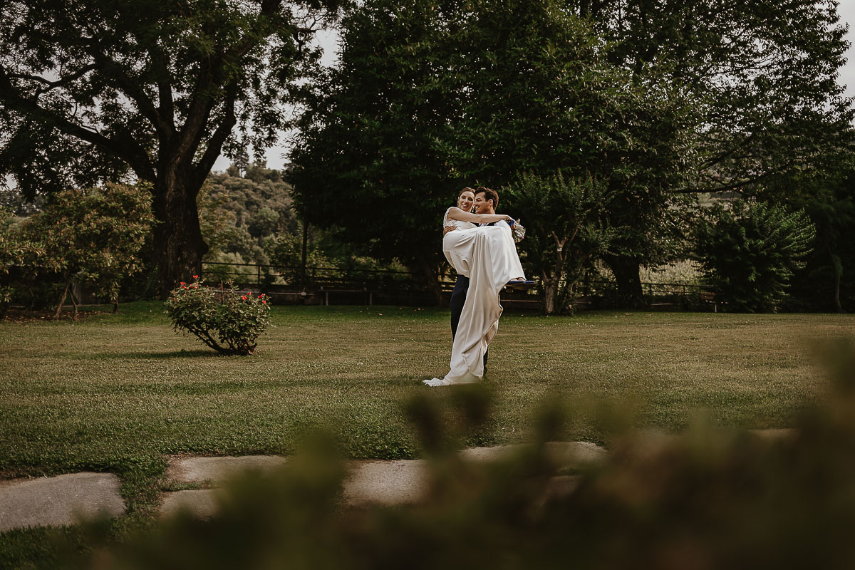 Castello Rosso di Costigliole di Saluzzo. Destination wedding. Sessione di coppia al tramonto.Sposo prende in braccio la sposa.