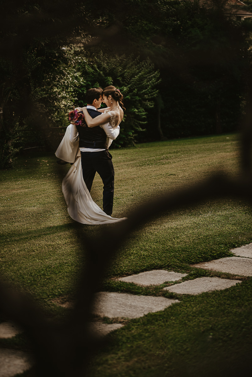 Castello Rosso di Costigliole di Saluzzo. Destination wedding. Sessione di coppia al tramonto. Sposo fa girare la sposa tenendola in braccio.