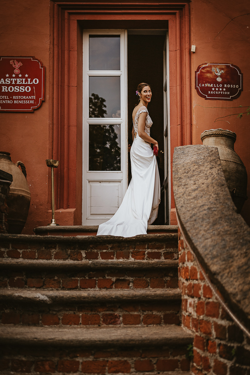 Castello Rosso di Costigliole di Saluzzo. Destination wedding. Sessione di coppia al tramonto. Sposa rientra nel castello.