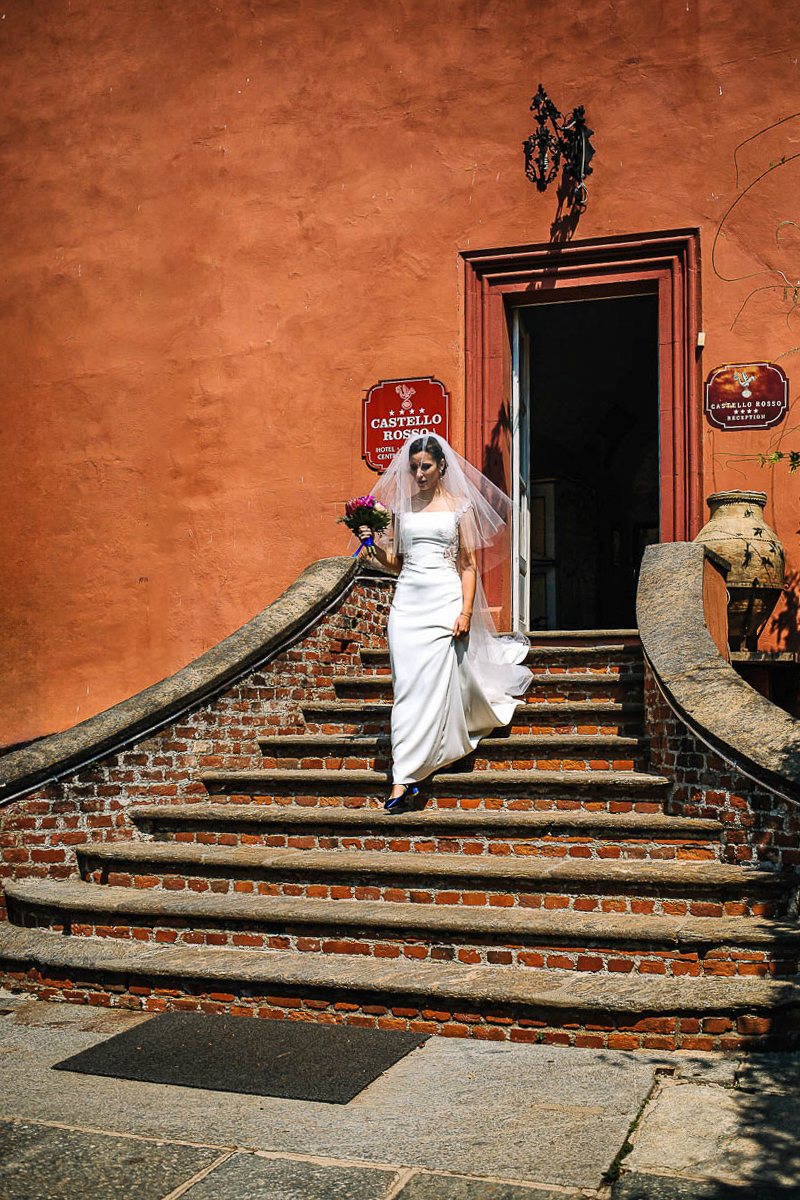 Castello Rosso di Costigliole di Saluzzo. Destination wedding. Cerimonia. Sposa esce dal castello.