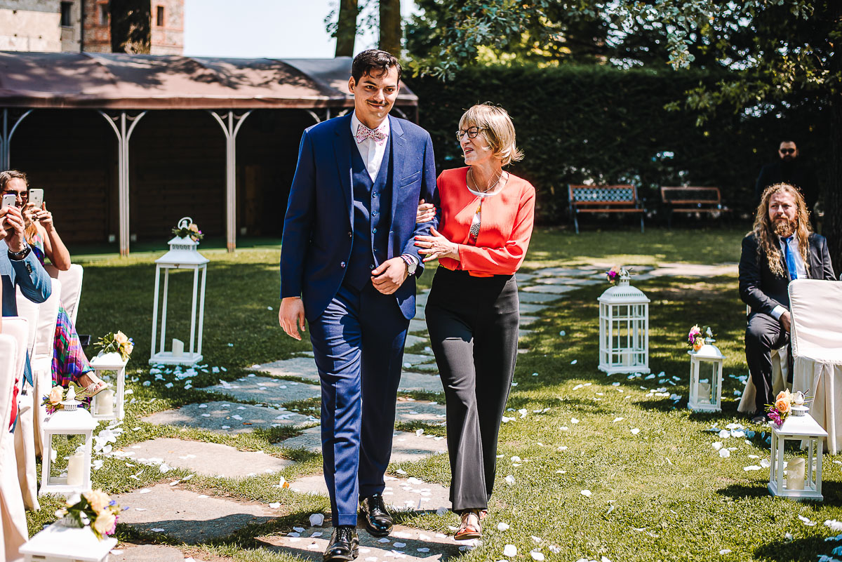 Castello Rosso di Costigliole di Saluzzo. Destination wedding. Cerimonia. Sposo fa il suo ingresso al braccio della mamma.