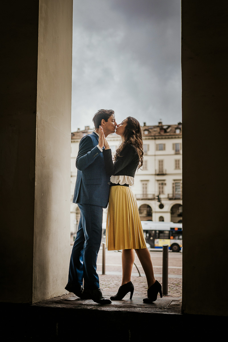 Engagement a Torino, in piazza Vittorio Veneto a Torino di Sara e Gabriel. Coppia sotto un arco dei portici si bacia.