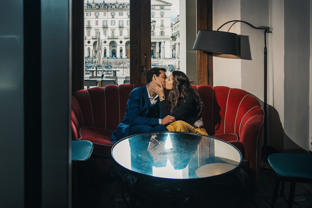Engagement a Torino, in piazza Vittorio Veneto a Torino di Sara e Gabriel. Coppia seduta su di un divano rosso nel locale "La Drogheria"