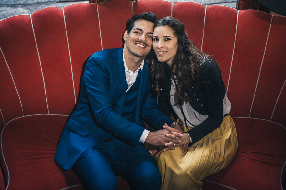 Engagement a Torino, in piazza Vittorio Veneto a Torino di Sara e Gabriel. Coppia seduta su di un divano rosso nel ocale "La Drogheria"
