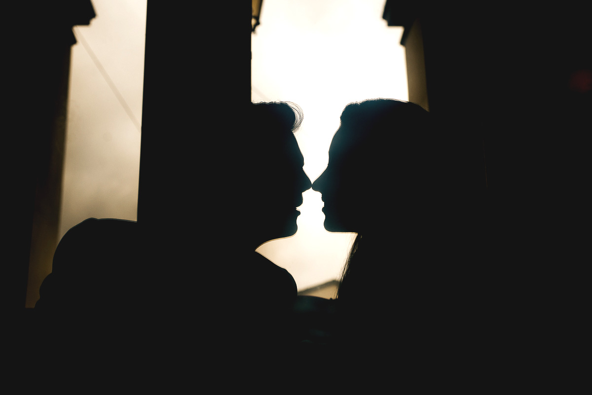 Engagement a Torino, in piazza Vittorio Veneto a Torino di Sara e Gabriel. Coppia seduta su di un divano rosso nel locale "La Drogheria" Silhouette riflessa in un tavolino di cristallo