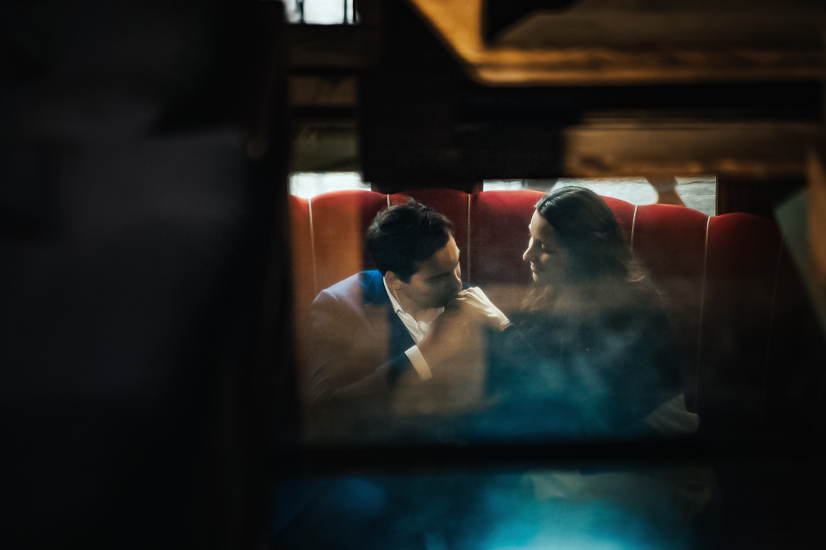 Engagement a Torino, in piazza Vittorio Veneto a Torino di Sara e Gabriel. Coppia seduta su di un divano rosso nel locale "La Drogheria" ripresa dal piano di sopra in vetro