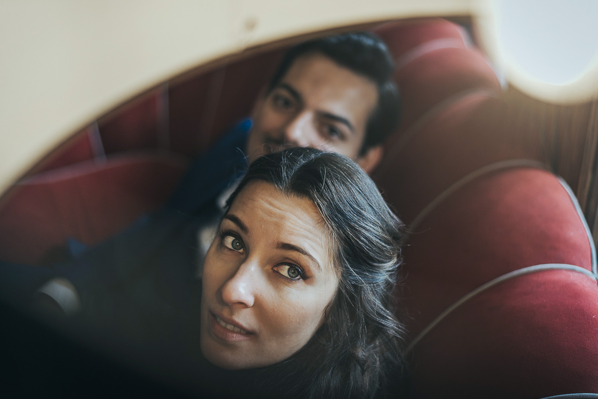Engagement a Torino, in piazza Vittorio Veneto a Torino di Sara e Gabriel. Coppia seduta su di un divano rosso nel locale "La Drogheria" ripresa dal piano di sopra in vetro