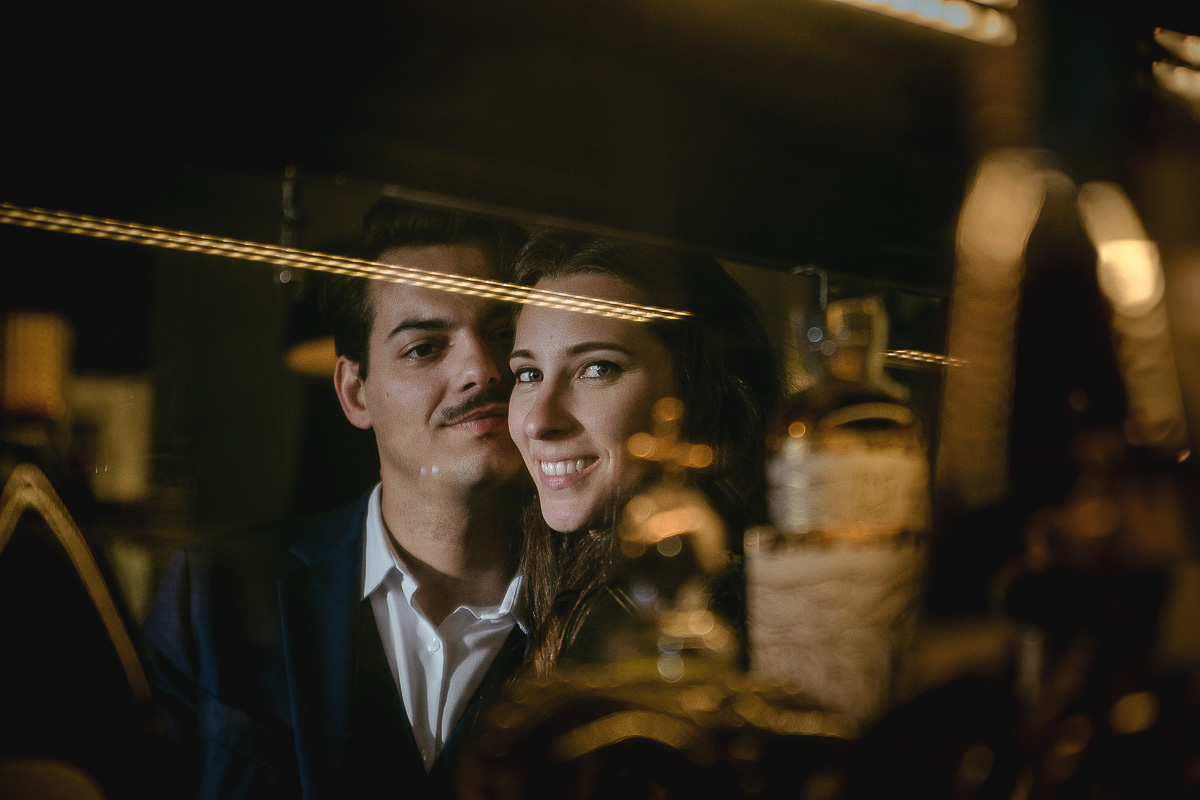 Engagement a Torino, in piazza Vittorio Veneto a Torino di Sara e Gabriel. Coppia riflessa nella vetrina dei dolci del locale La Drogheria