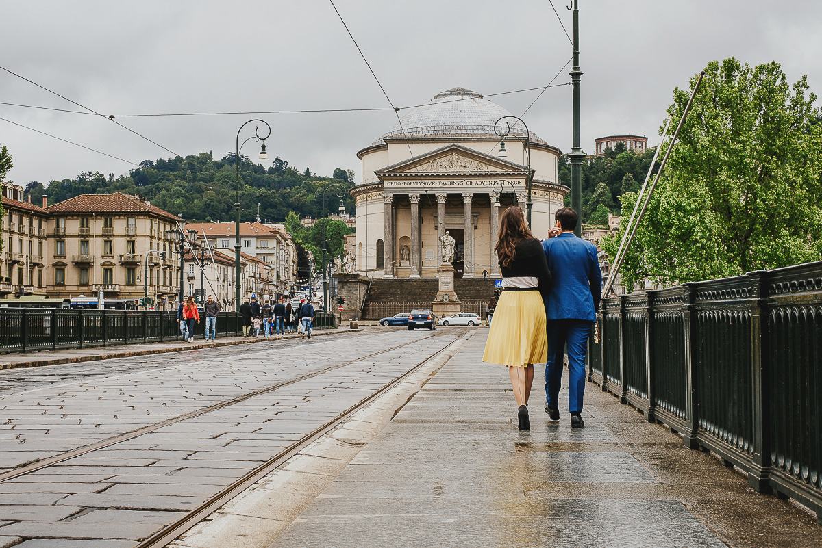 Engagement a Torino, in piazza Vittorio Veneto a Torino di Sara e Gabriel. Coppia cammina sul ponte della Gran Madre.