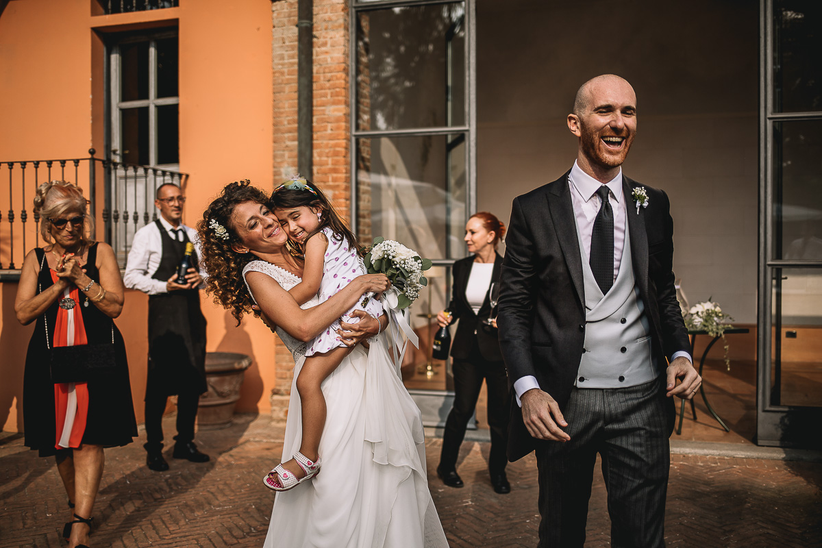 Matrimonio nella Villa dei Marchesi di Moncrivello. Servizio di coppia.Aperitivo.Sposa che prende in braccio una bambina.