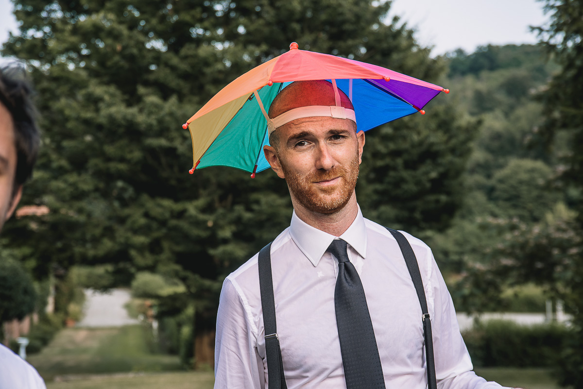 Matrimonio nella Villa dei Marchesi di Moncrivello. Servizio di coppia.Aperitivo.Sposo con un buffo cappello ombrellino arcobaleno
