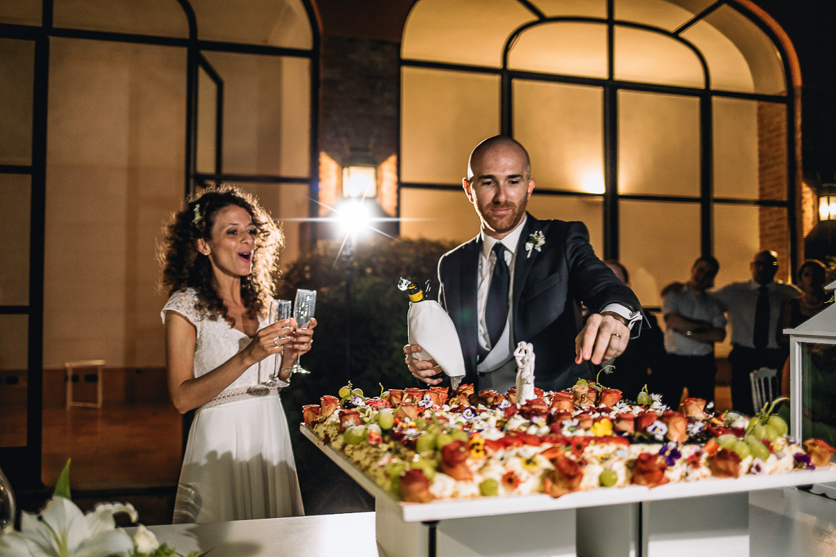 Matrimonio nella Villa dei Marchesi di Moncrivello. Servizio di coppia.Taglio della torta.Sposo che recupera il tappo di sughero che è finito nella torta.