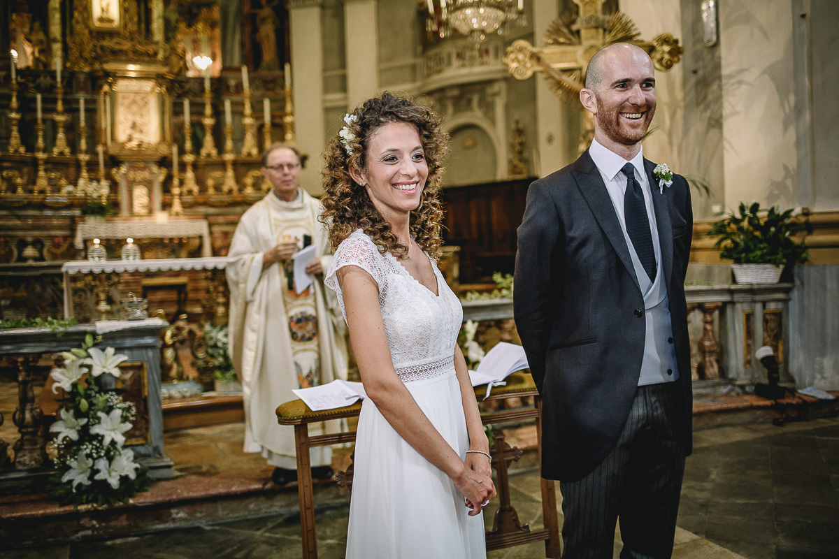 Matrimonio nella Chiesa Parrocchiale di Strambino. Sposi che sorridono mentre attendono le damigelle che portamo gli anelli