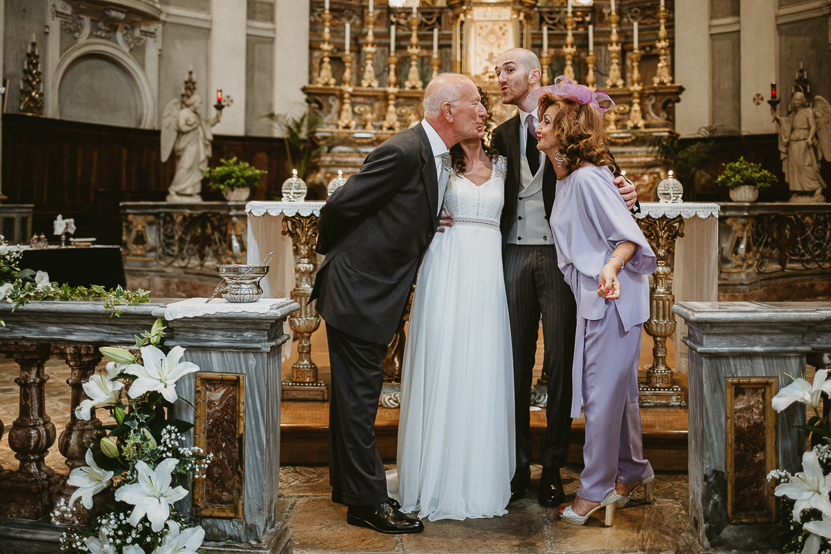 Matrimonio nella Chiesa Parrocchiale di Strambino. Foto con i genitori dello sposo che stanno per baciarsi