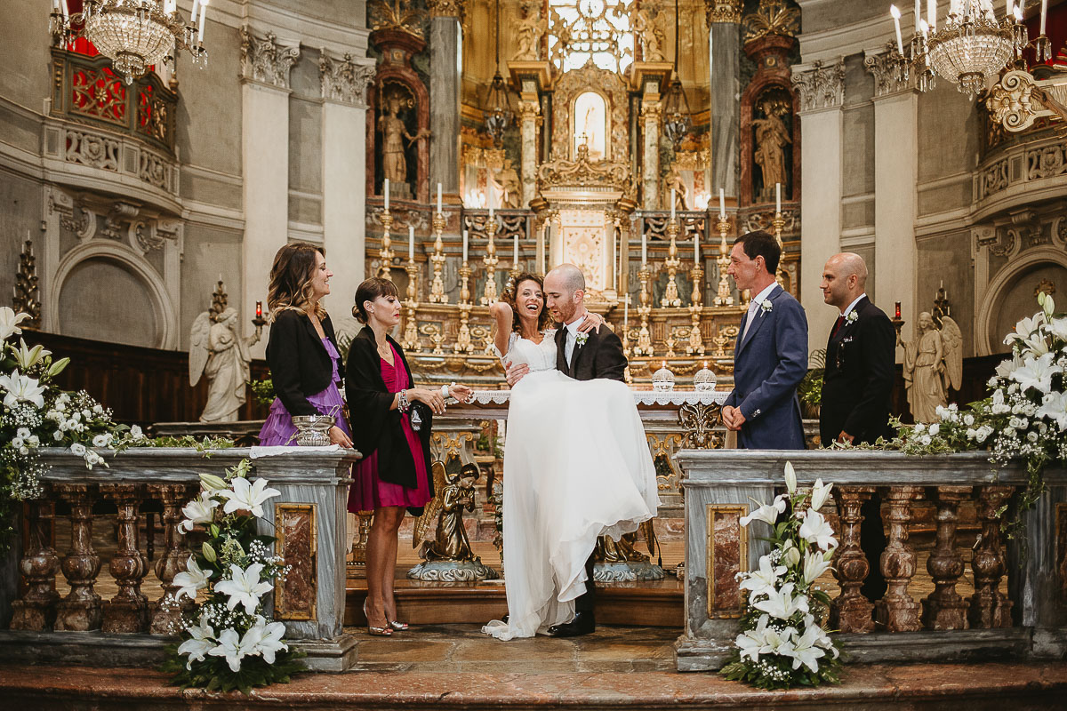 Matrimonio nella Chiesa Parrocchiale di Strambino. Foto con i testimoni. sposo prende in braccio la sposa.