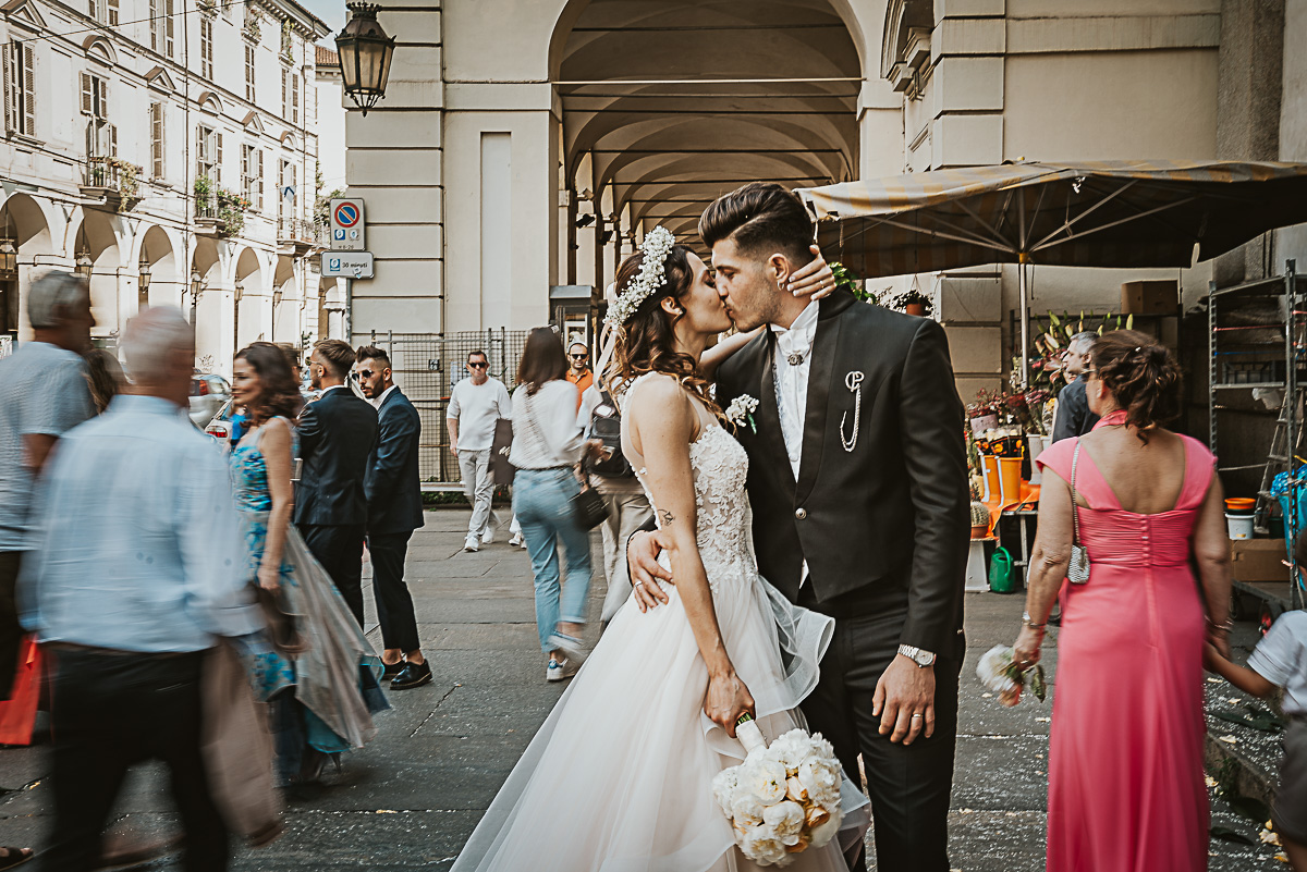 Matrimonio a Torino. Chiesa di san Francesco da Paola. Messa.Uscita degli sposi Bacio degli sposi in via Po con la gente che passa