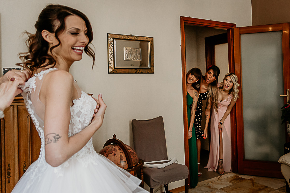 Matrimonio a Torino. Preparazione della sposa. Vestizione della sposa. damigelle che guardano dalla porta.