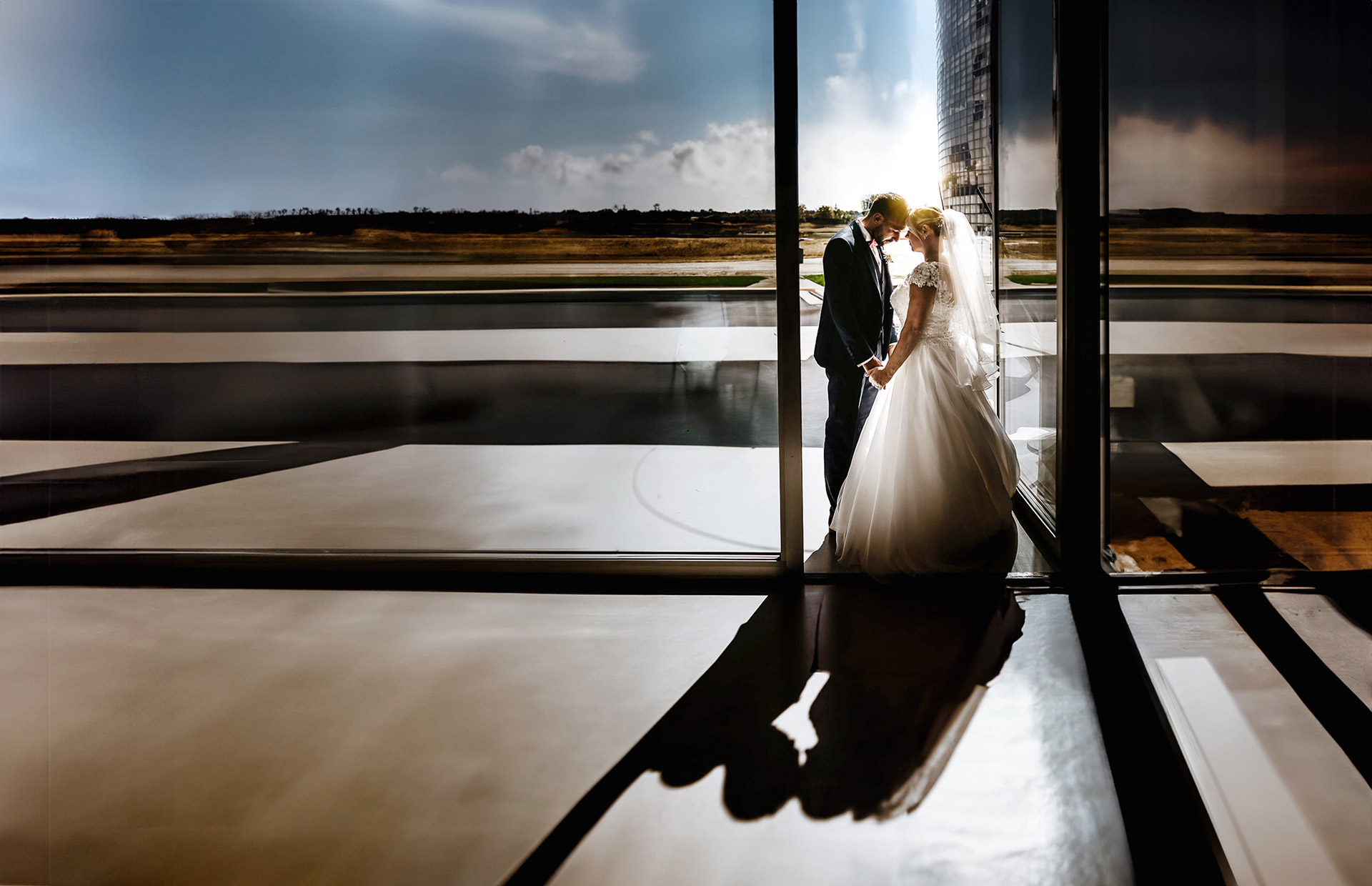 Casa Format, matrimonio, sessione fotografica di coppia. Sposi frone fronte in controluce con sole dietro di loro e ombra sul pavimento.