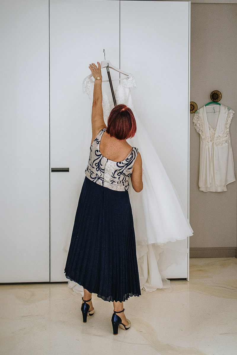 Casa Format, matrimonio italo-marocchino. Preparazione della sposa. mamma prende il vestito della sposa.