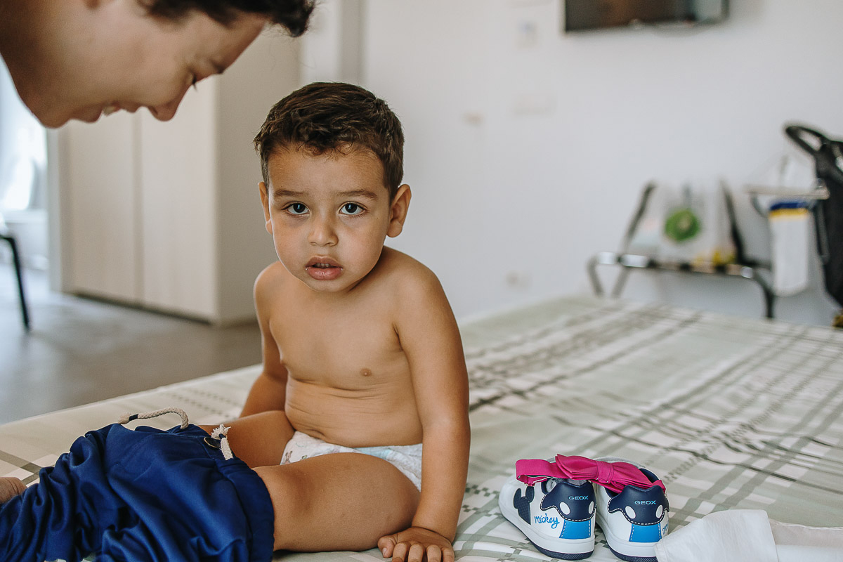 Casa Format, matrimonio italo-marocchino. Preparazione degli sposi. Baby sitter veste il figlio degli sposi.