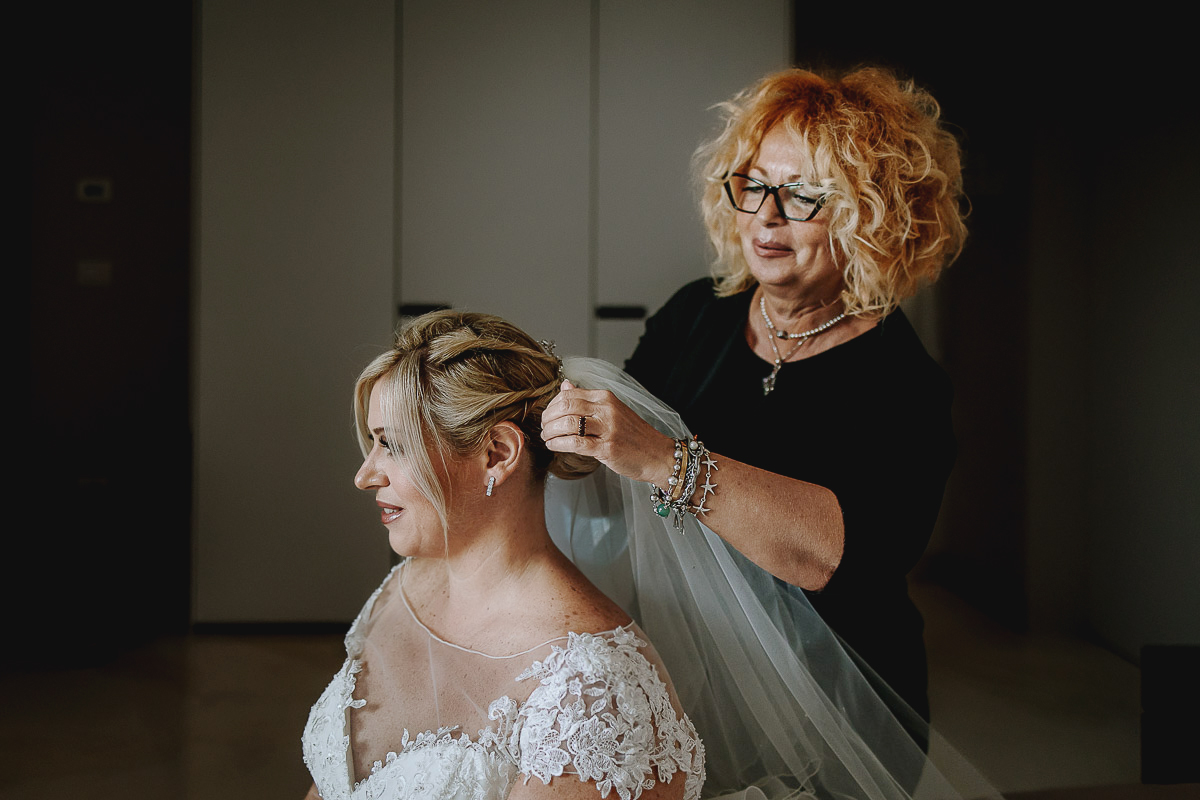 Casa Format, matrimonio italo-marocchino. Preparazione della sposa. Parrucchiera mette il velo alla sposa.