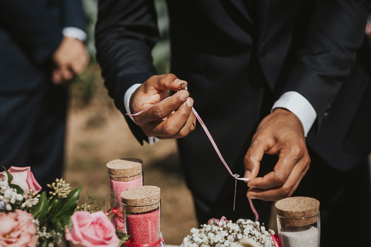 Casa Format, matrimonio italo-marocchino. Cerimonia. Sposo sfila l'anello dal cuscinetto fiorito.