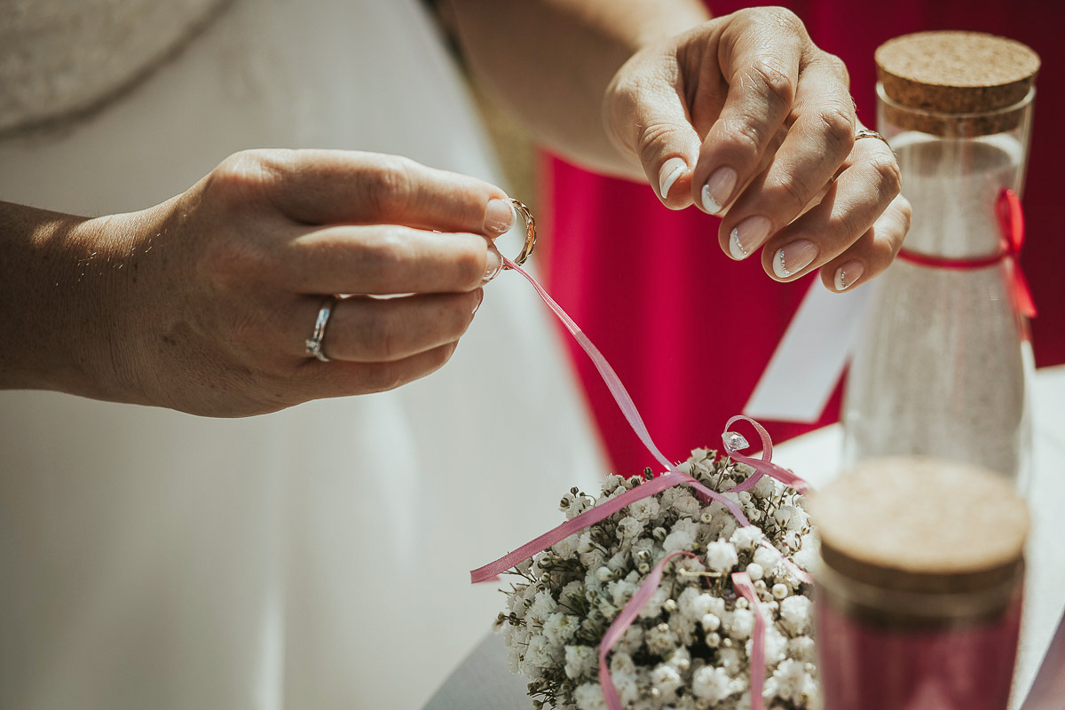 Casa Format, matrimonio italo-marocchino. Cerimonia. Sposa sfila l'anello dal cuscinetto fiorito.