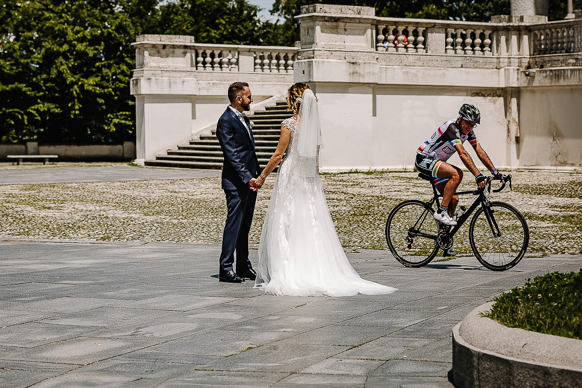Matrimonio a Superga. Servizio di Coppia.Sposi davanti alla basilica. Ciclista che passa.