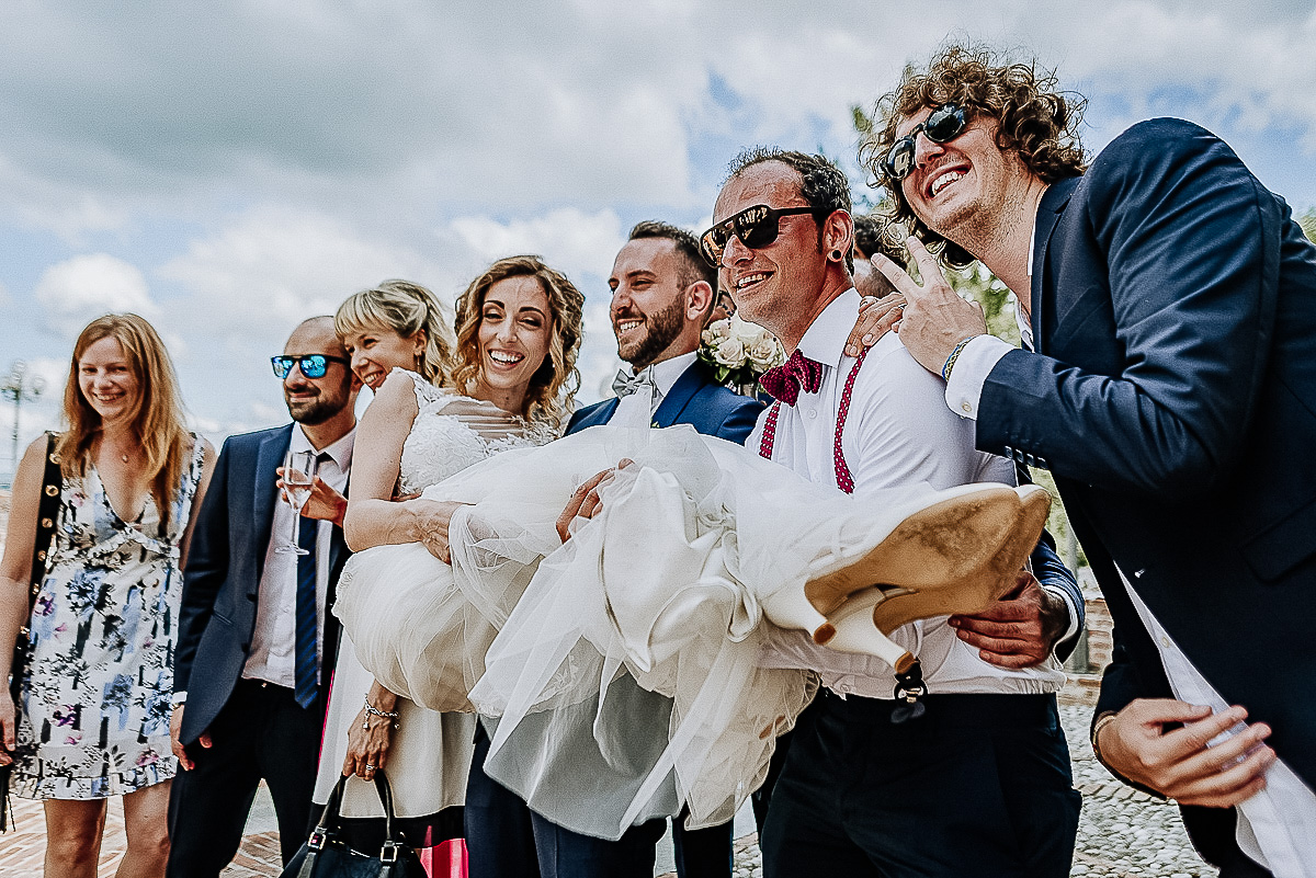 Matrimonio al castello di Cortanze. Aperitivo.Amici che prendono in braccio la sposa.