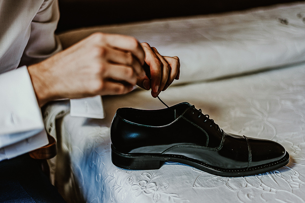 Matrimonio a Torino, preparazione dello sposo. Sposo che allaccia le scarpe