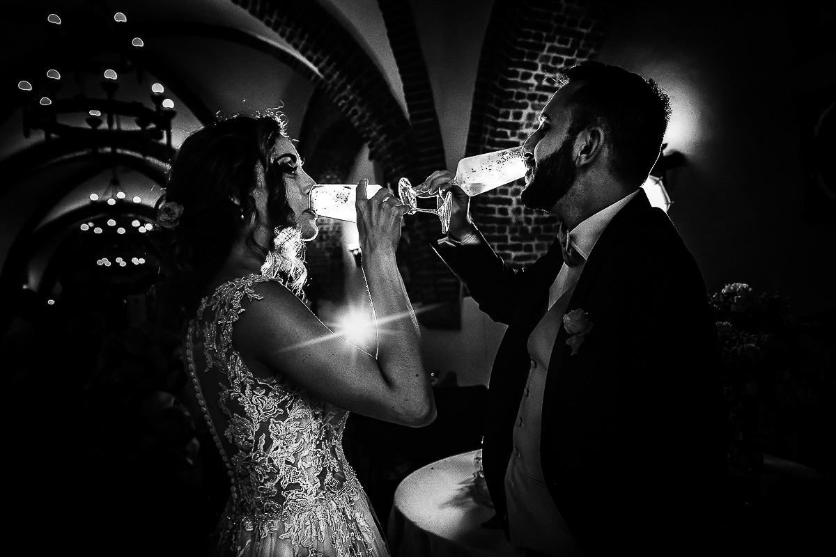 Matrimonio al castello di Cortanze. Ricevimento. Taglio della torta brindisi finale degli sposi, bianco e nero.