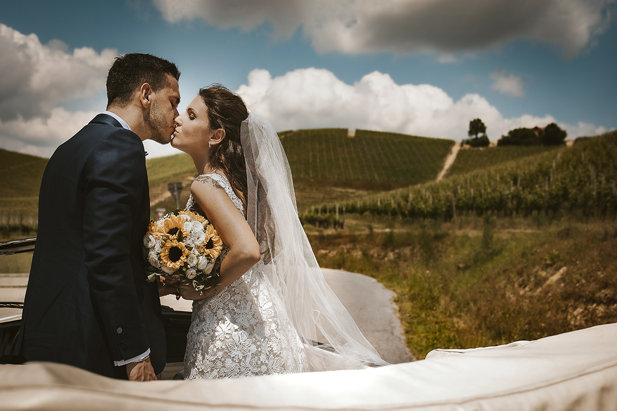 Tenuta Fontanfredda, bacio degli sposi in piedi in auto da dietro