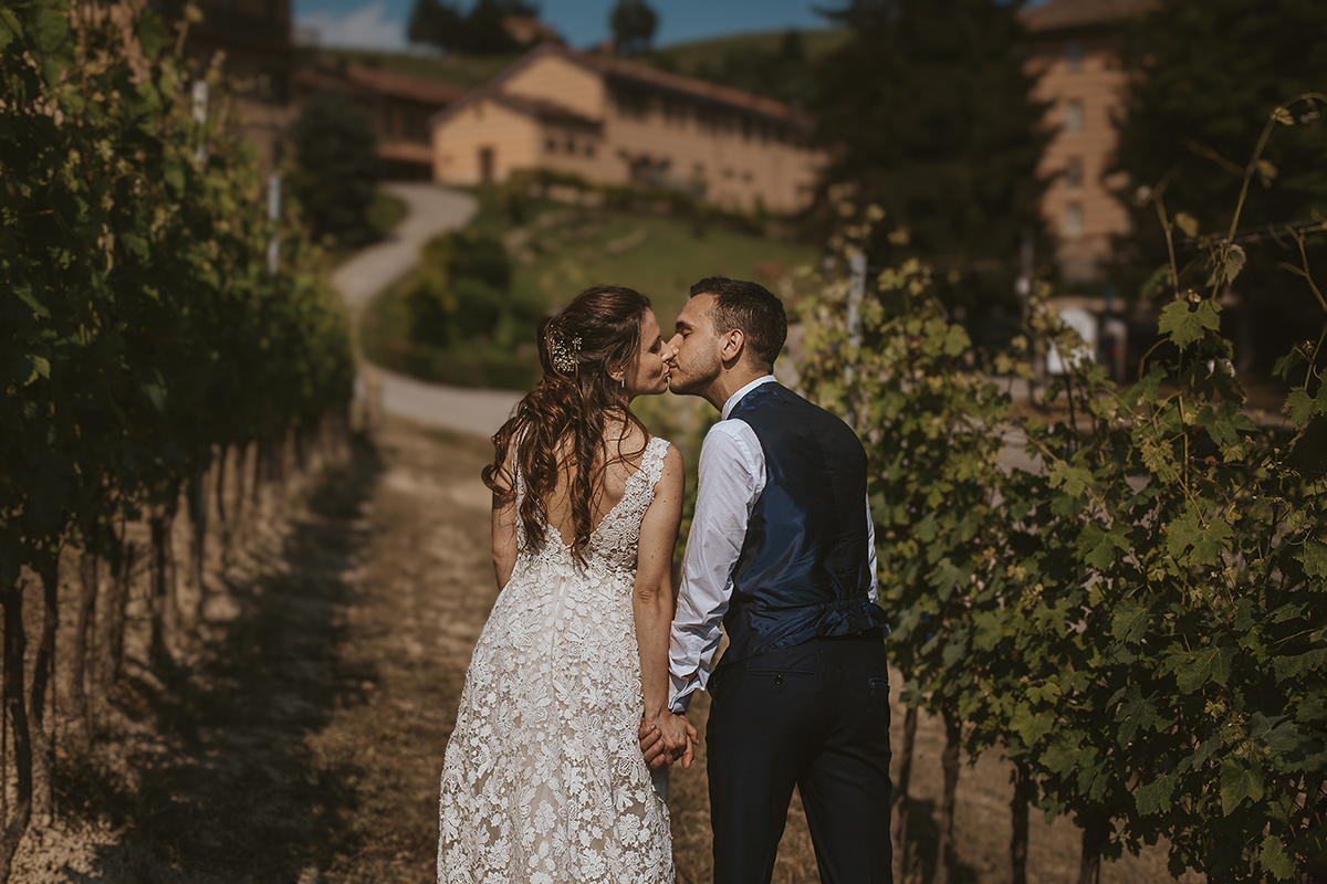Tenuta Fontanfredda, Guidoristorante. Villa reale.Sessione fotografica degli sposi tra le vigne. Bacio degli sposi da dietro.