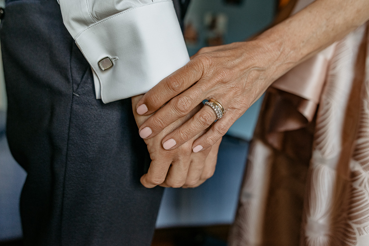 Matrimonio a Torino. Preparazione dello sposo. Particolare delle mani dello sposo e della mamma.