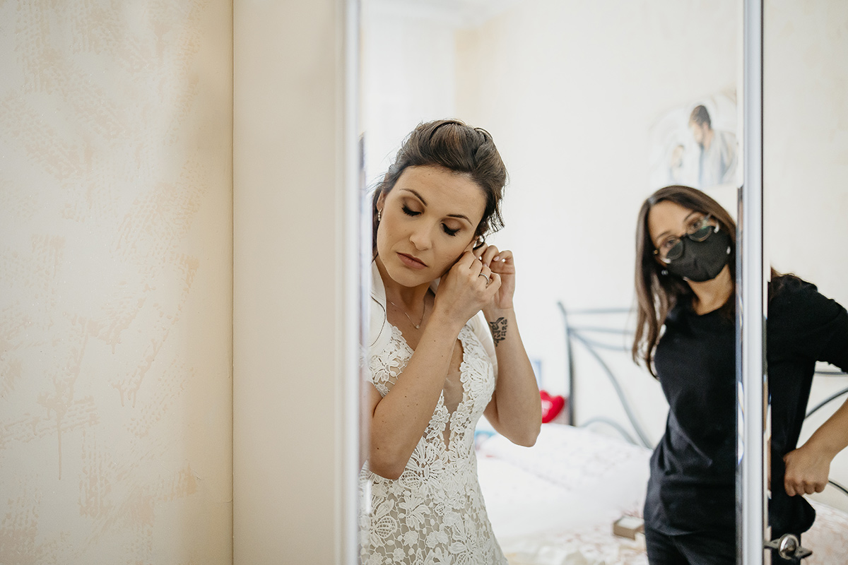 Matrimonio a Torino. Preparazione della sposa.Sposa si mette gli orecchini
