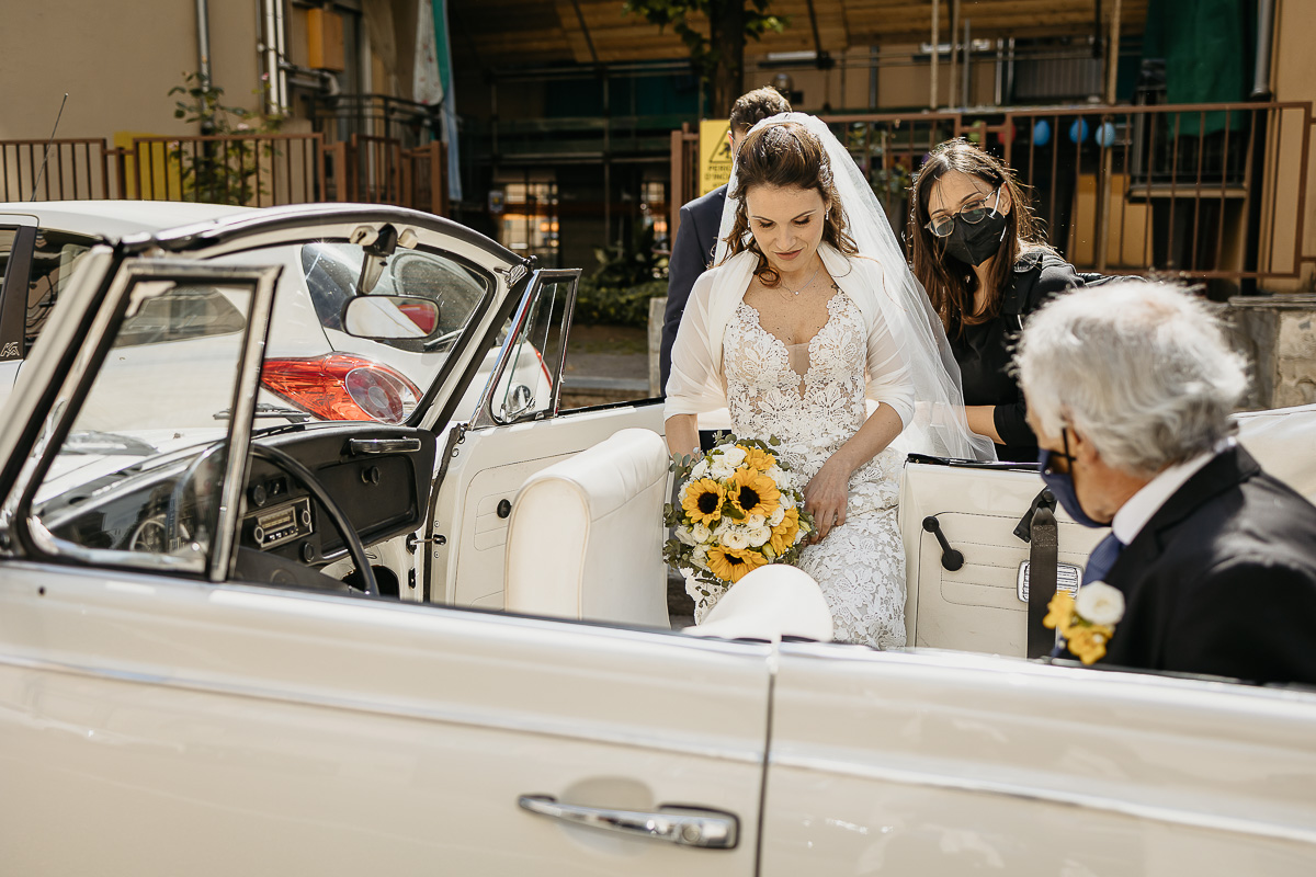 Matrimonio a Torino. Preparazione della sposa.Sposa sale in auto, un maggiolone bianco scoperto, con il padre