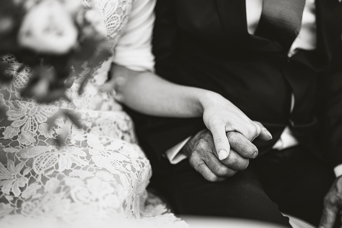 Matrimonio a Torino. Preparazione della sposa. Particolare delle mani della sposa e del padre in auto.