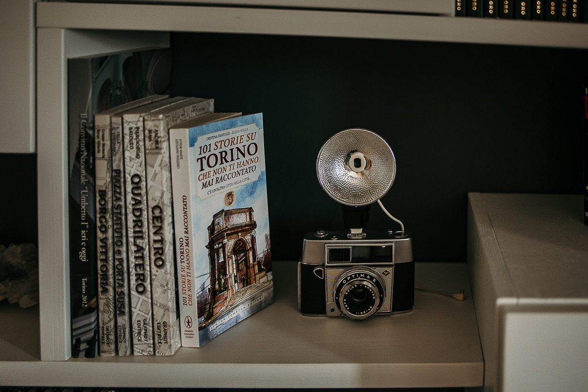 Matrimonio a Torino in un palazzo storico di Piazza Statuto. Preparazione della sposa. vecchia macchina fotografica e libri.