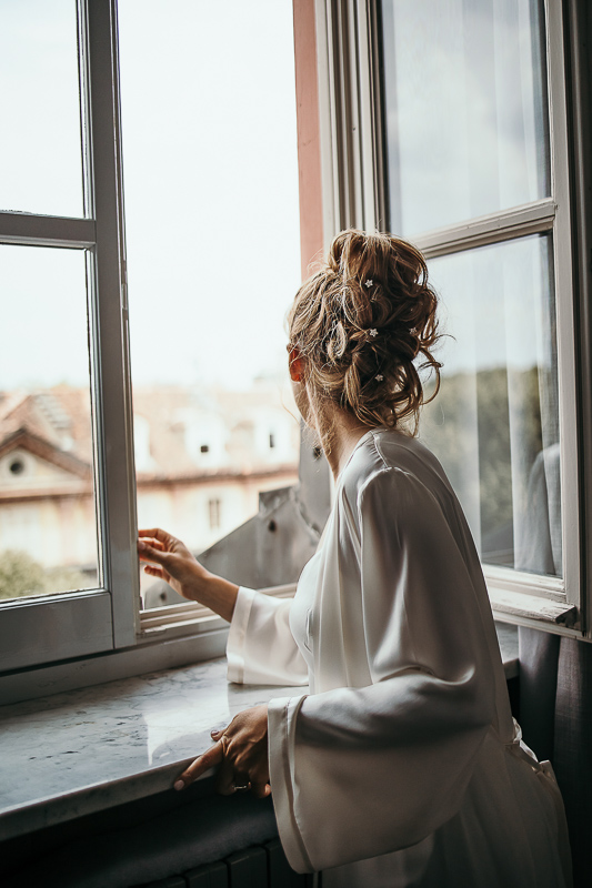 Matrimonio a Torino in un palazzo storico di Piazza Statuto. Preparazione della sposa. Sposa alla finestra.