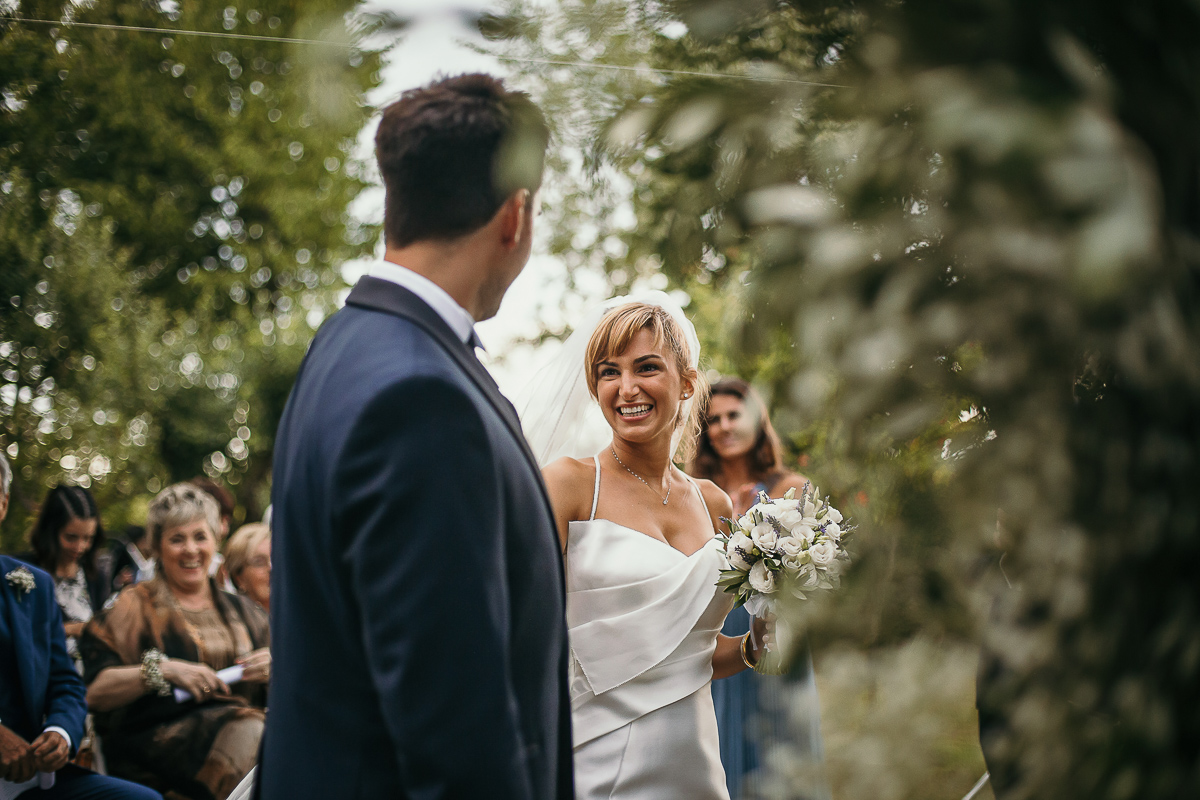 Matrimonio a Villa Delfini di Morsasco (AL) nel Monferrato. Cerimonia.. sposa guarda lo sposo.