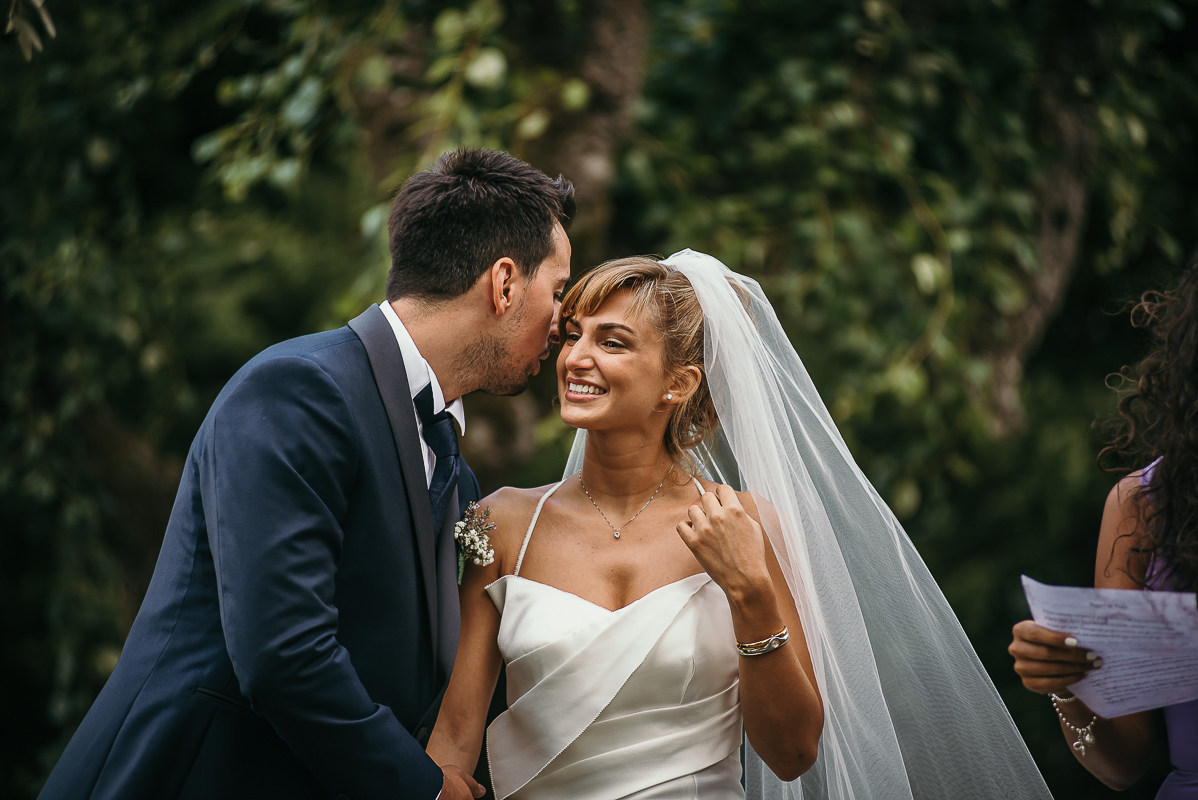 Matrimonio a Villa Delfini di Morsasco (AL) nel Monferrato. Cerimonia. sposo che dice qualcosa all'orecchio della sposa.