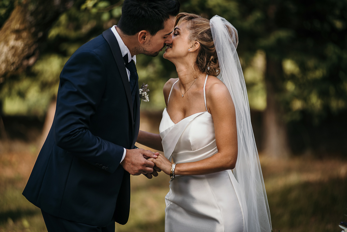 Matrimonio a Villa Delfini di Morsasco (AL) nel Monferrato. Cerimonia.. sposi si baciano tenendosi per mano.